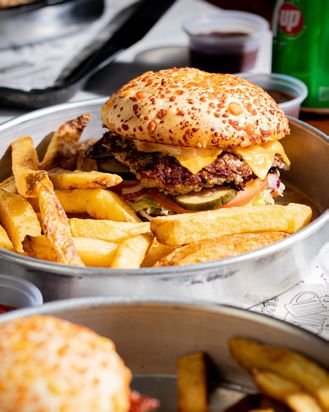 Hamburguesa acompañada de papas fritas en bandeja metálica