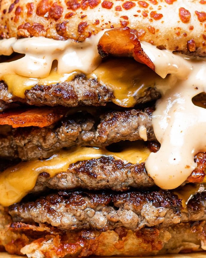 Primer plano de medallones apilados con cheddar fundido y panceta